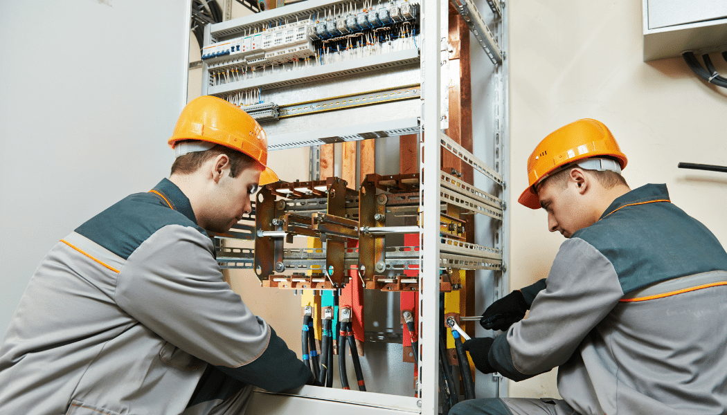 deux électriciens qui répare un tableaux électrique