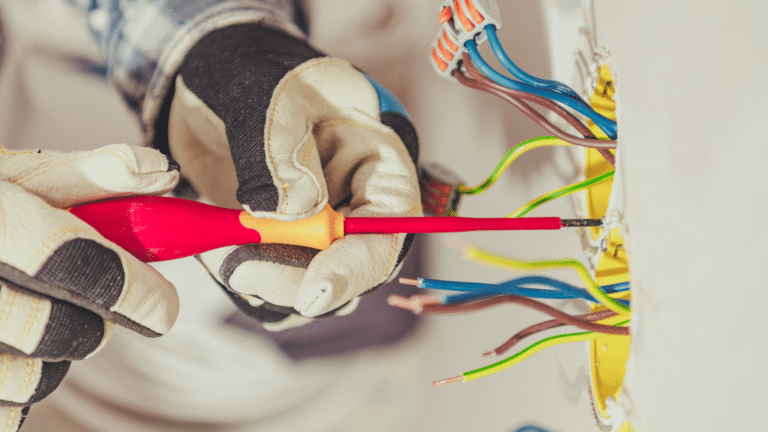 électricien qui visse un cache à fils conducteurs